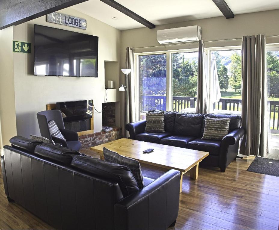 ein Wohnzimmer mit Ledermöbeln und einem Tisch in der Unterkunft Gateside Chalets 6 Bedroom Hot Tub Near Village in Blue Mountains