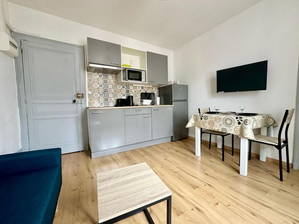 un salon avec une table et une cuisine dans l'établissement Le Saint Georges, cosy et calme, à Limoges