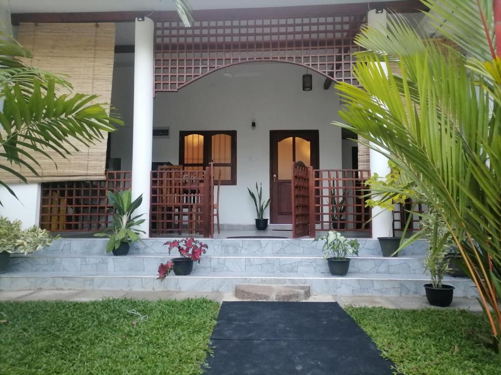 a front view of a house with stairs and plants at Villa 96 in Unawatuna