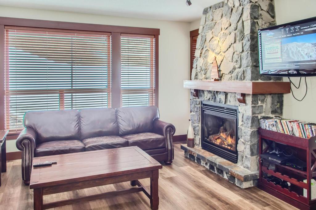 a living room with a couch and a fireplace at Stonegate Resort Unit C202 in Big White