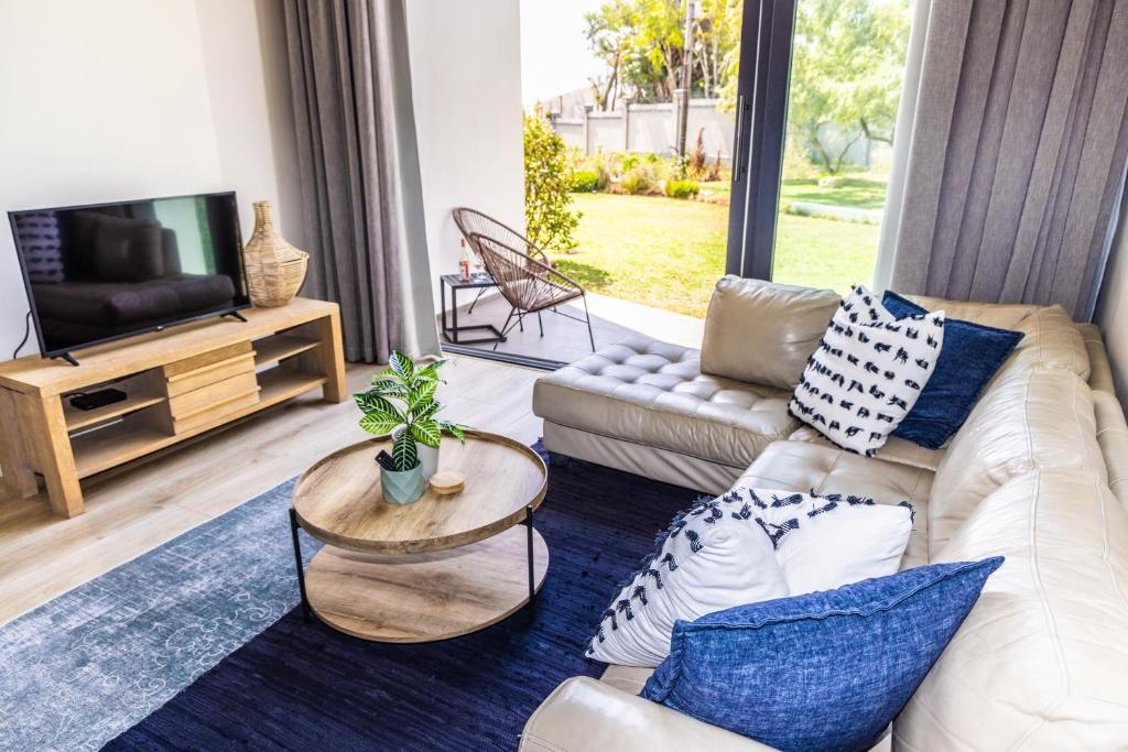 a living room with a couch and a tv at 4 Lulworth in Johannesburg