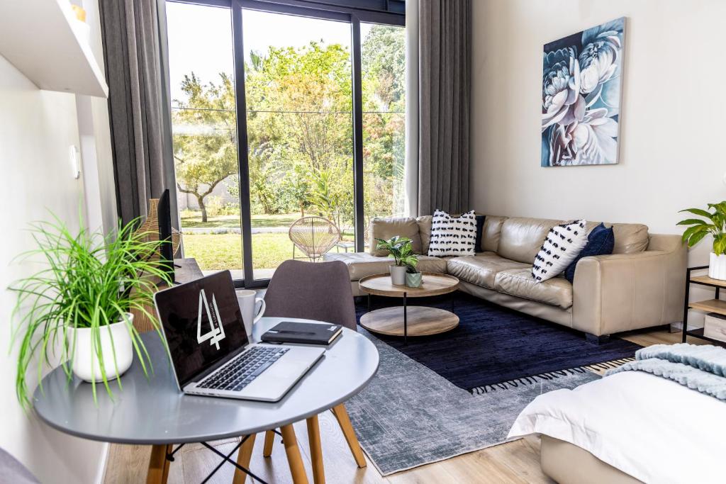 a living room with a table with a laptop on it at 4 Lulworth in Johannesburg