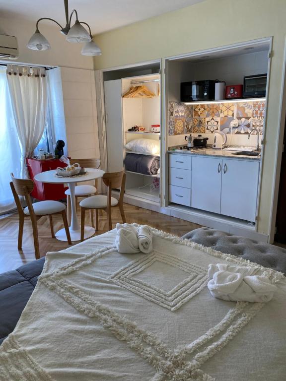 a bedroom with a bed and a kitchen and a table at Encantador estudio in Buenos Aires