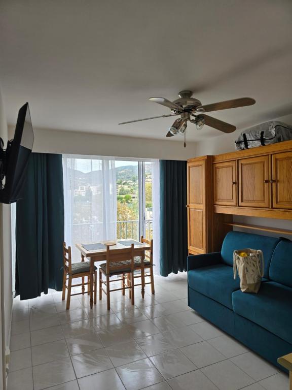 a living room with a blue couch and a table at Olivier in Le Lavandou