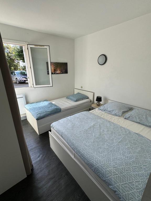 - 2 lits dans une chambre avec un miroir et une fenêtre dans l'établissement T3 à Poitiers proche du Futuroscope, à Poitiers