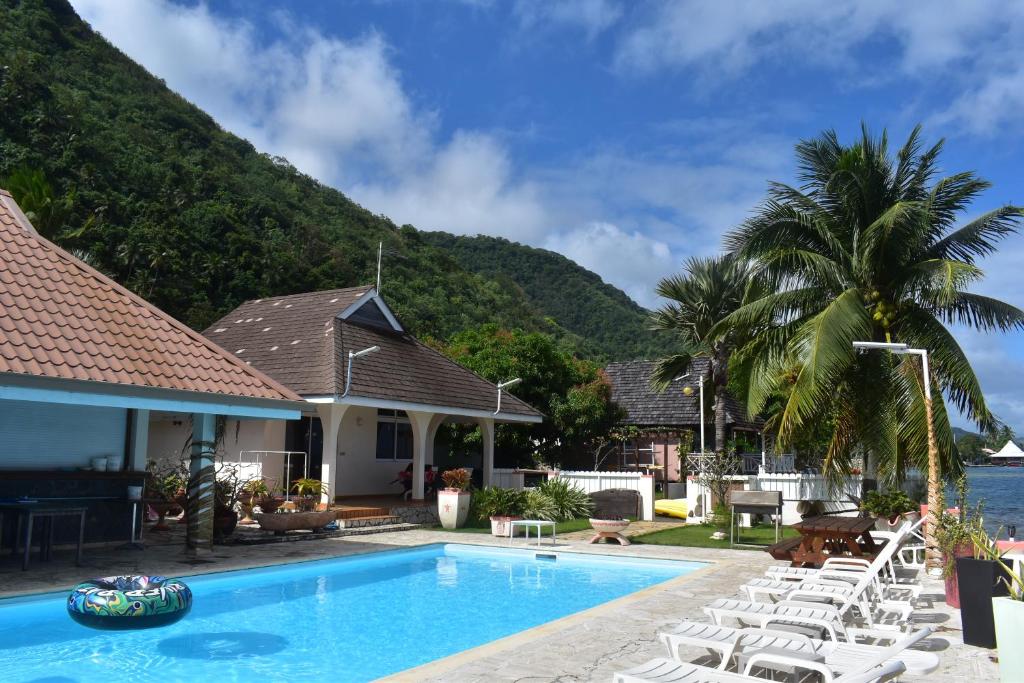 a resort with a swimming pool and lounge chairs at Pension de famille HITI MOANA VILLA in Papara