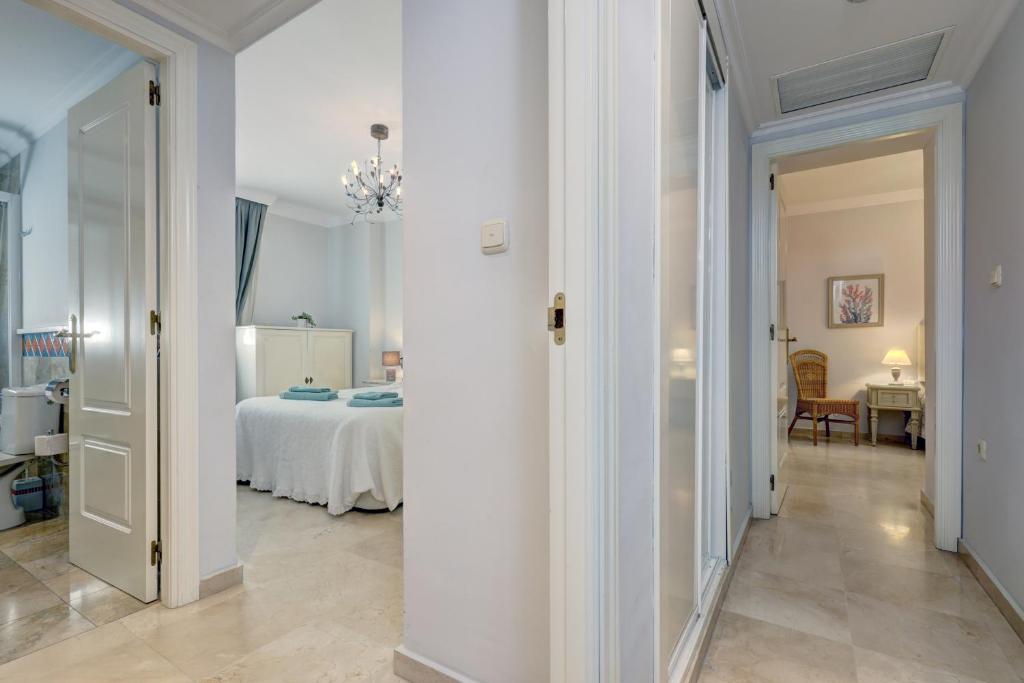 a hallway with a room with a bed and a chandelier at Banana Beach primera línea de playa in Marbella