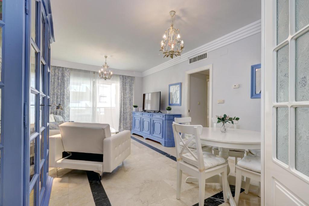 a dining room with a white table and chairs at Banana Beach primera línea de playa in Marbella