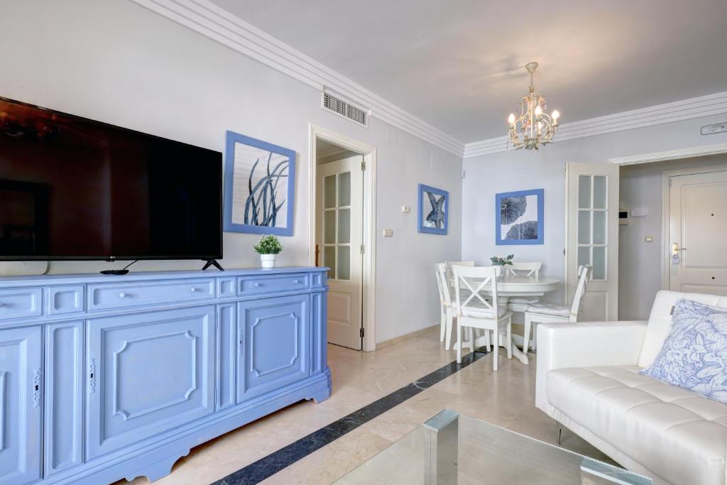 a living room with a blue cabinet with a flat screen tv at Banana Beach primera línea de playa in Marbella