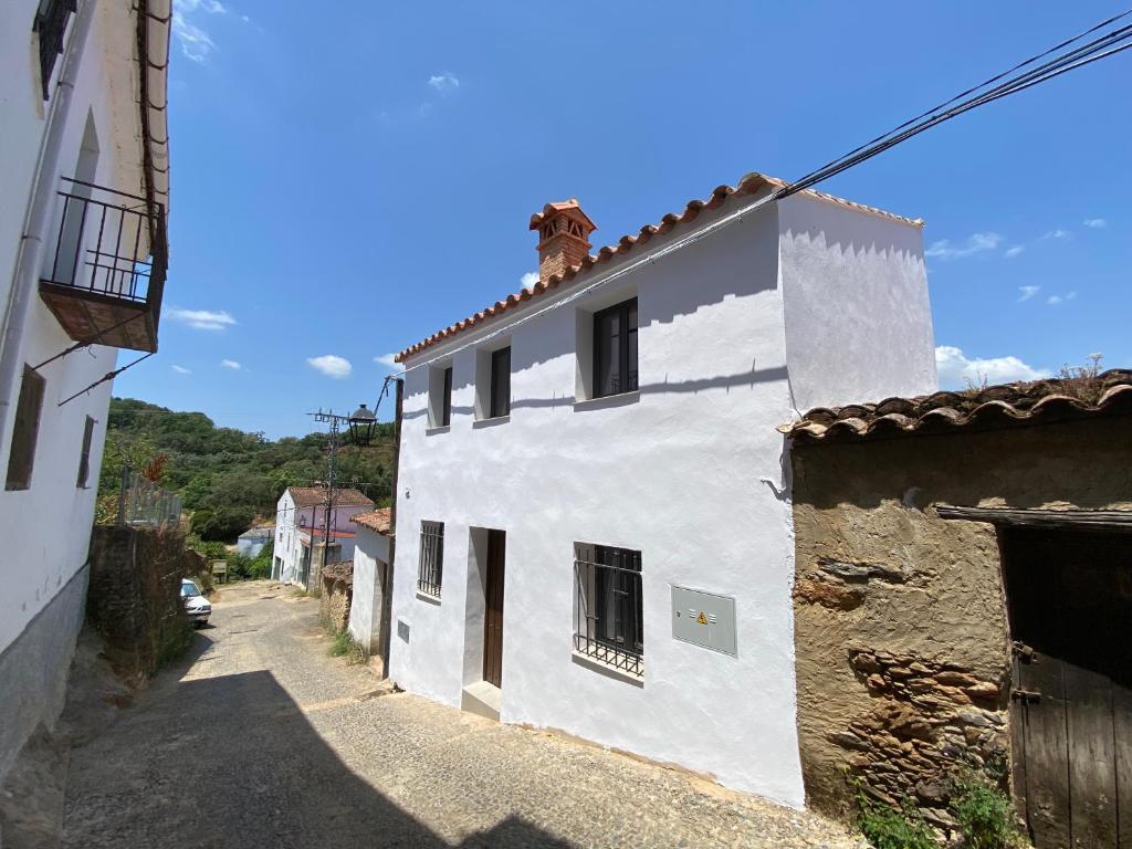 an alley with a white building on a street at La Casa de mi Tía María in Cortelazor