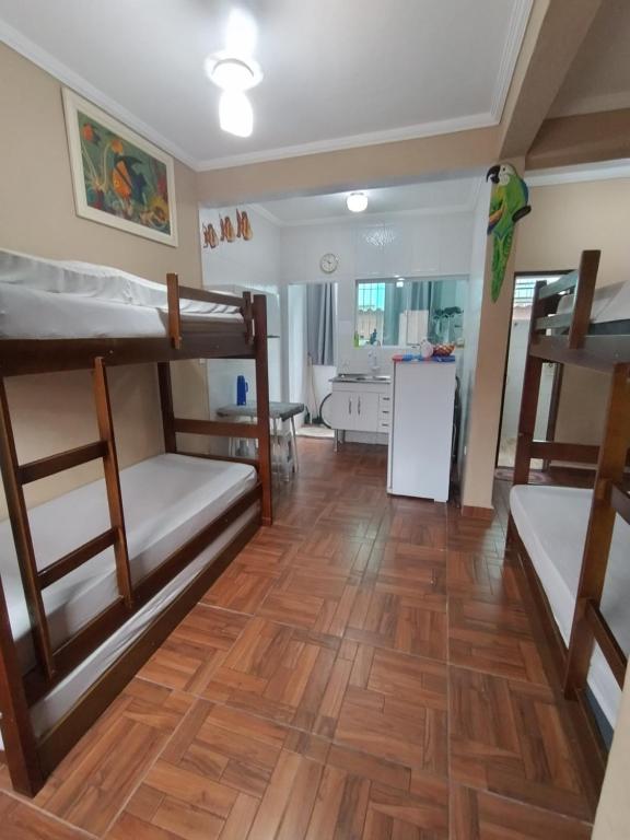 Zimmer mit 3 Etagenbetten und einer Küche in der Unterkunft Apto no Centro de Bertioga, próx a Praia da Enseada e da Balsa com acesso a Prainha Branca, Acomoda até 6 pessoas in Bertioga