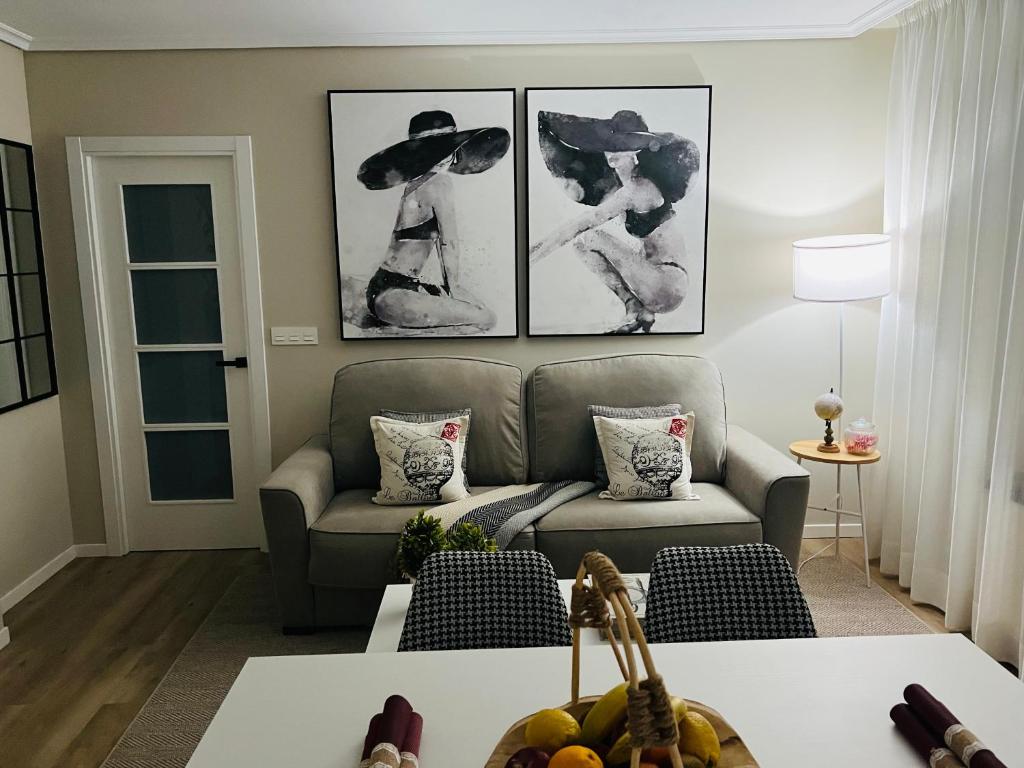 a living room with a couch and pictures on the wall at RioMar in Redondela