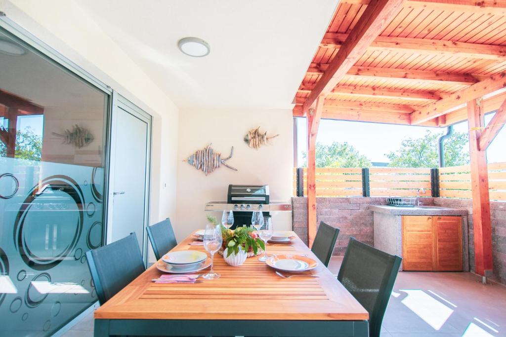 a dining room with a wooden table and chairs at Apartment Maja Medulin in Medulin