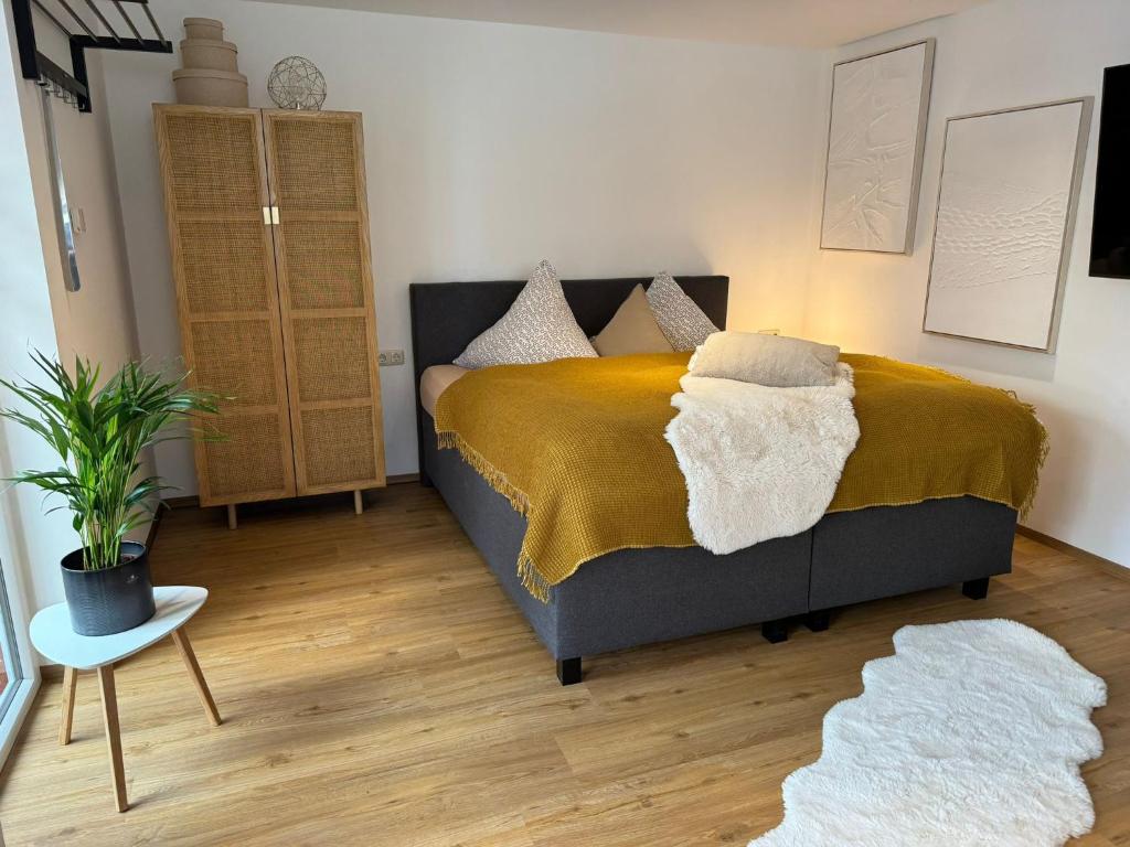 1 dormitorio con 1 cama con manta amarilla en Ferienwohnung Neue Quickbox, en Thale