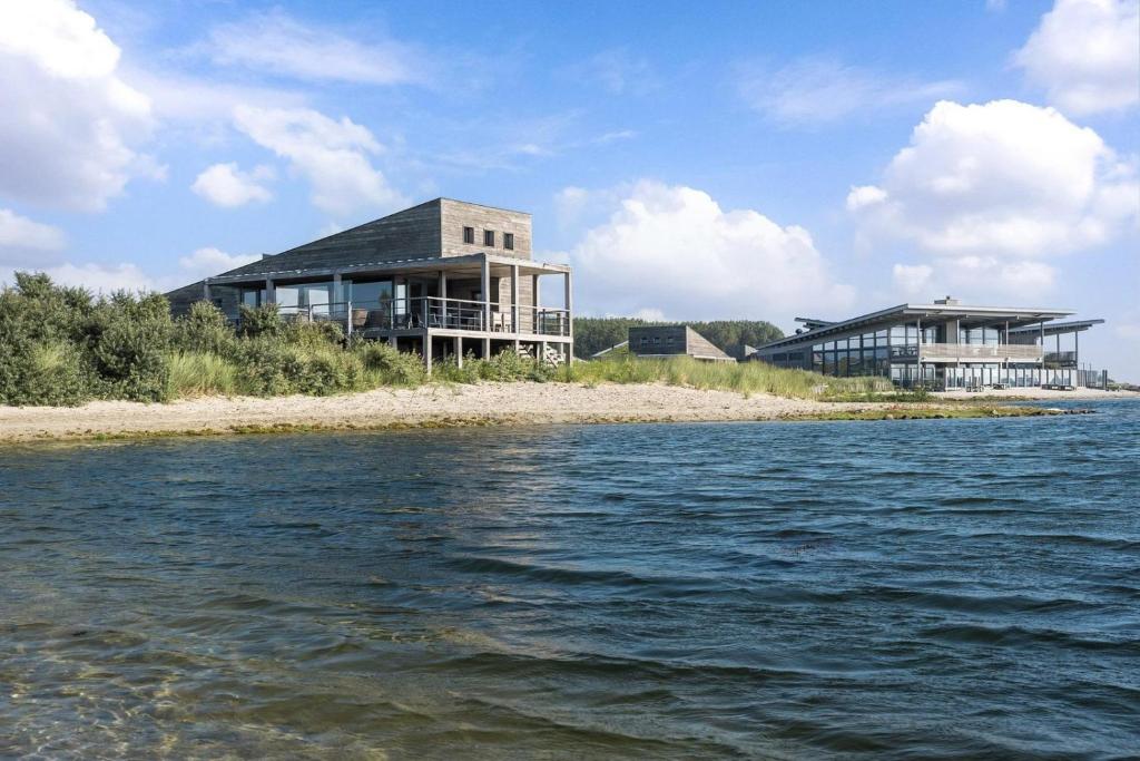 a house on the shore of a body of water at Grevelingenmeer Panorama Villa 4p - Luxe & Natuur - Villa 14 in Ouddorp