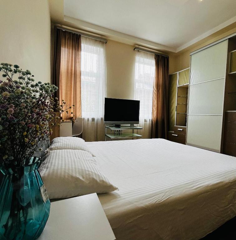 a bedroom with a bed and a vase of flowers at Iren Politech apartment in Lviv