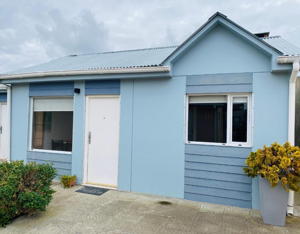 a blue house with two windows and a door at Casita María in Puerto San Julián