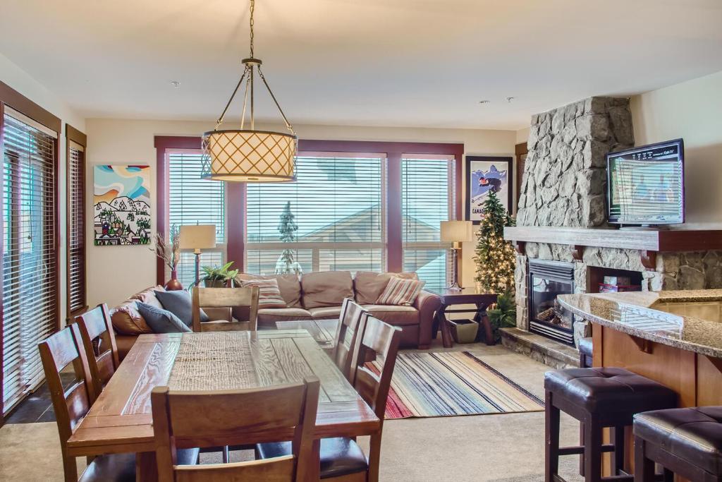 a living room with a table and a fireplace at Stonegate Resort Unit A202 in Big White