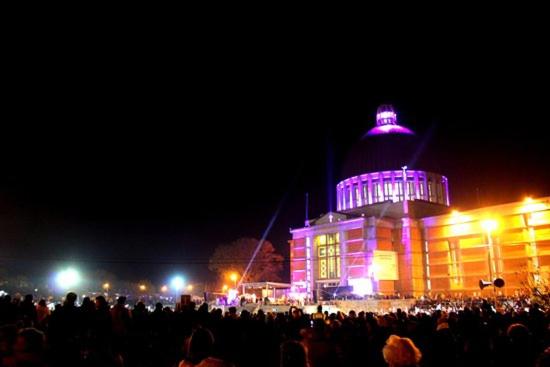 a crowd of people standing in front of a building with purple lights at Departamentos la Merced in San Nicolás de los Arroyos