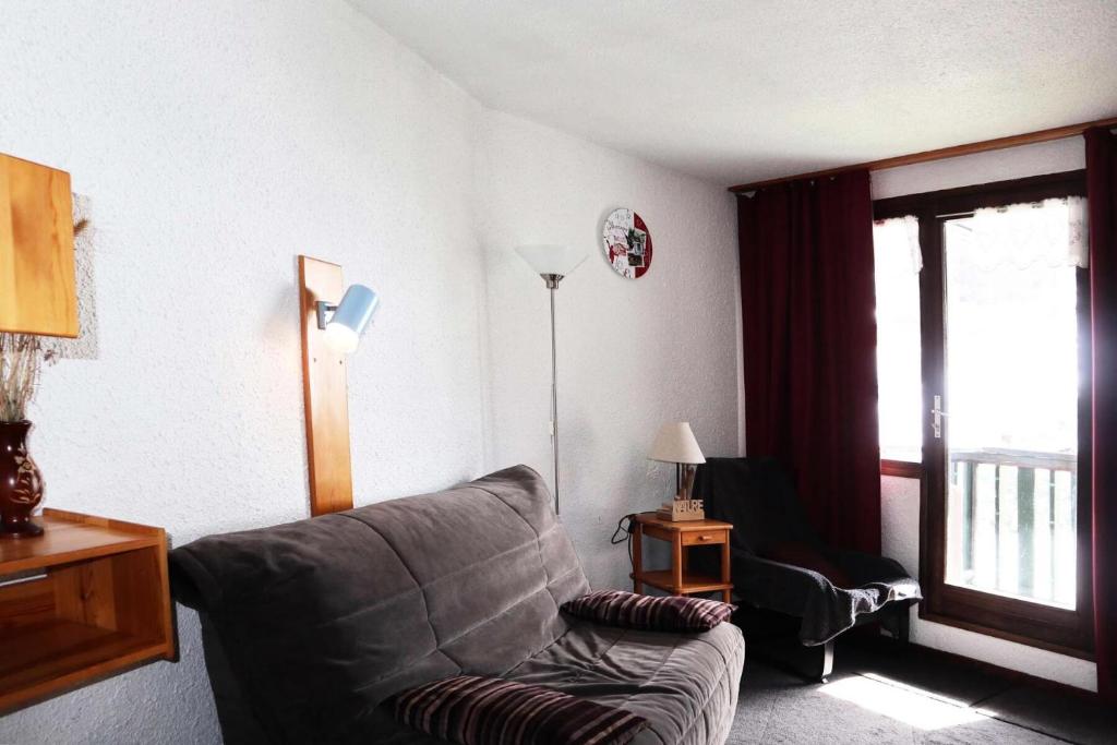 un salon avec un canapé et une fenêtre dans l'établissement Résidence Le Cairn - Résidence Cairn - Studio 4 personnes vue pistes MAE-6291, aux Orres