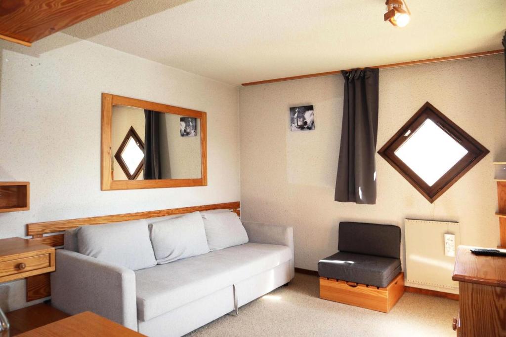 un salon avec un canapé et une fenêtre dans l'établissement Résidence Le Cairn - studio 6 personnes le cairn N°705 MAE-6571, aux Orres