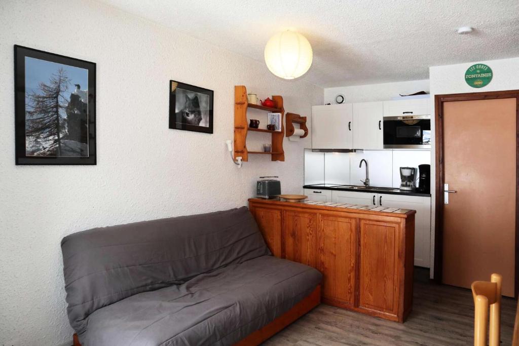 un salon avec un canapé et une cuisine dans l'établissement Résidence Le Cairn - Résidence Cairn - Studio 4 personnes vue pistes MAE-6381, aux Orres