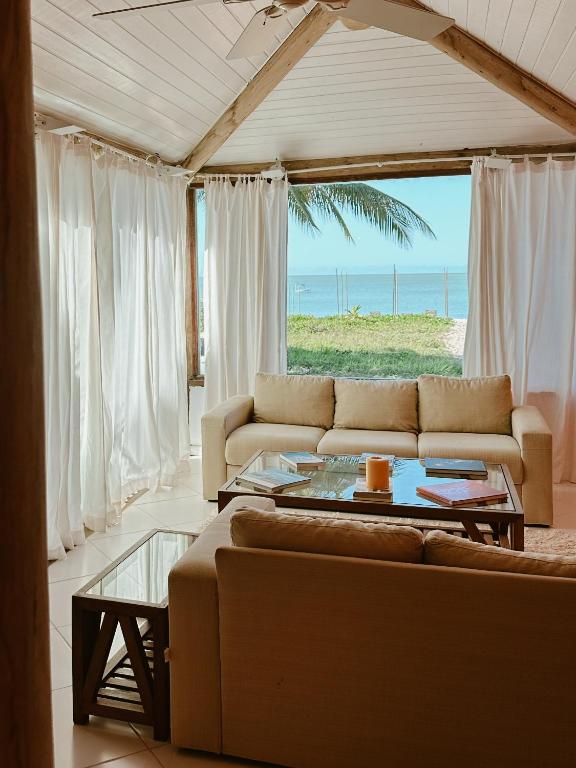 a living room with a couch and a table at Casa Ponta de Areia in Corumbau