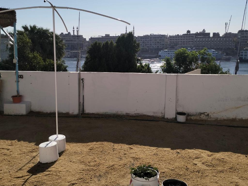 a white fence with two potted plants on a patio at Roma House in Aswan