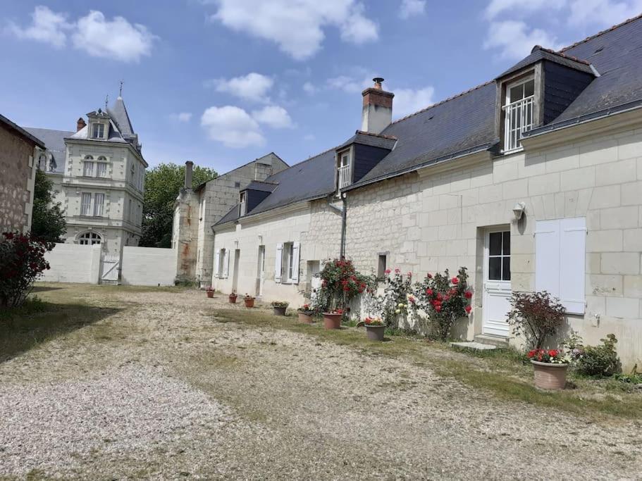 Un bâtiment blanc avec des fleurs sur son côté dans l'établissement Maison pour 6 personnes, à Villebernier