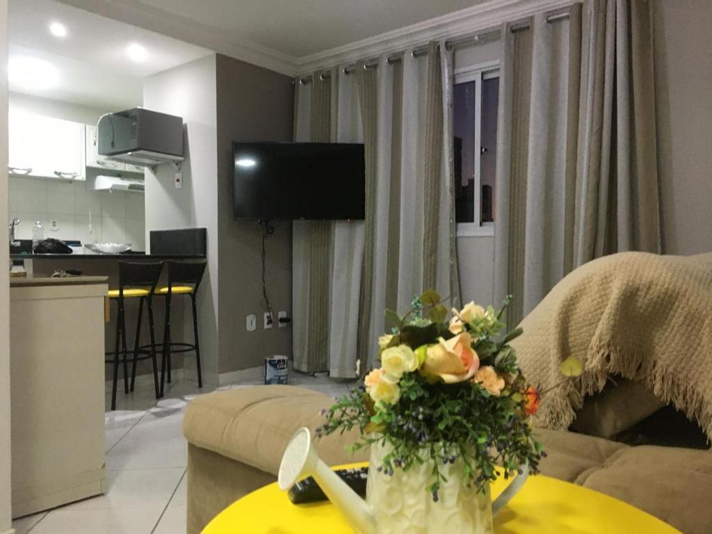 a living room with a vase of flowers on a table at Apto com Ar Cond e Wifi Super Confortável in Guarapari