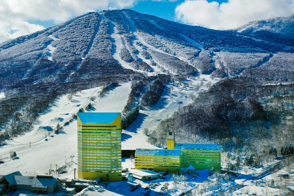 un edificio frente a una montaña nevada en ANA Crowne Plaza Resort Appi Kogen, an IHG Hotel en Hachimantai