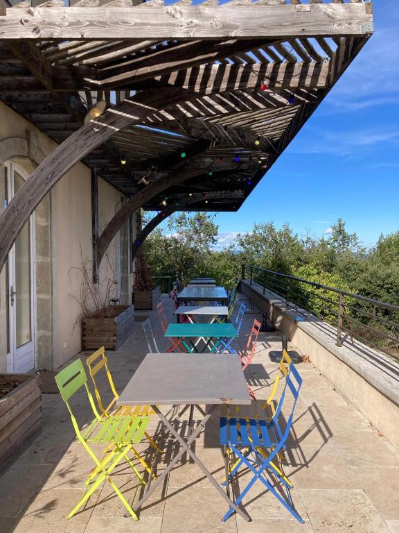 un patio avec une table et des chaises sur un toit dans l'établissement Maison de vacances 12 chambres et piscine, à Colognac