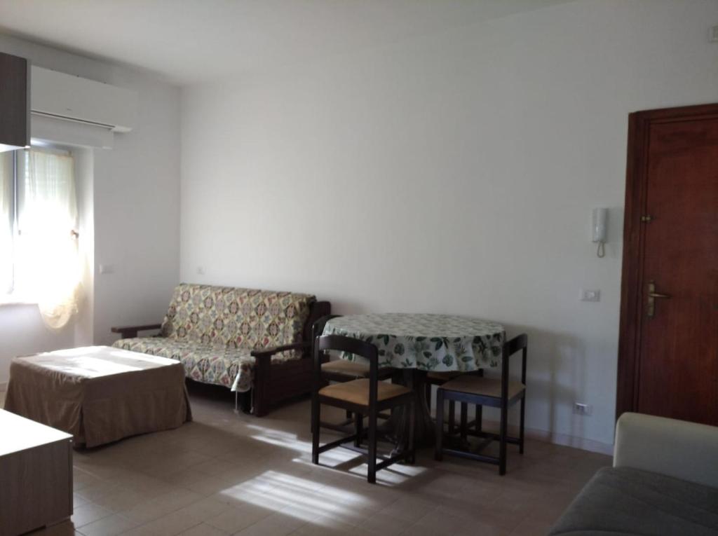 a living room with a couch and a table and a chair at La casa di Enrico & Giusy in Passoscuro