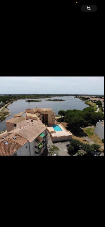 Vue aérienne d'un bâtiment et d'une masse d'eau dans l'établissement Appartement le grau du roi, au Grau-du-Roi