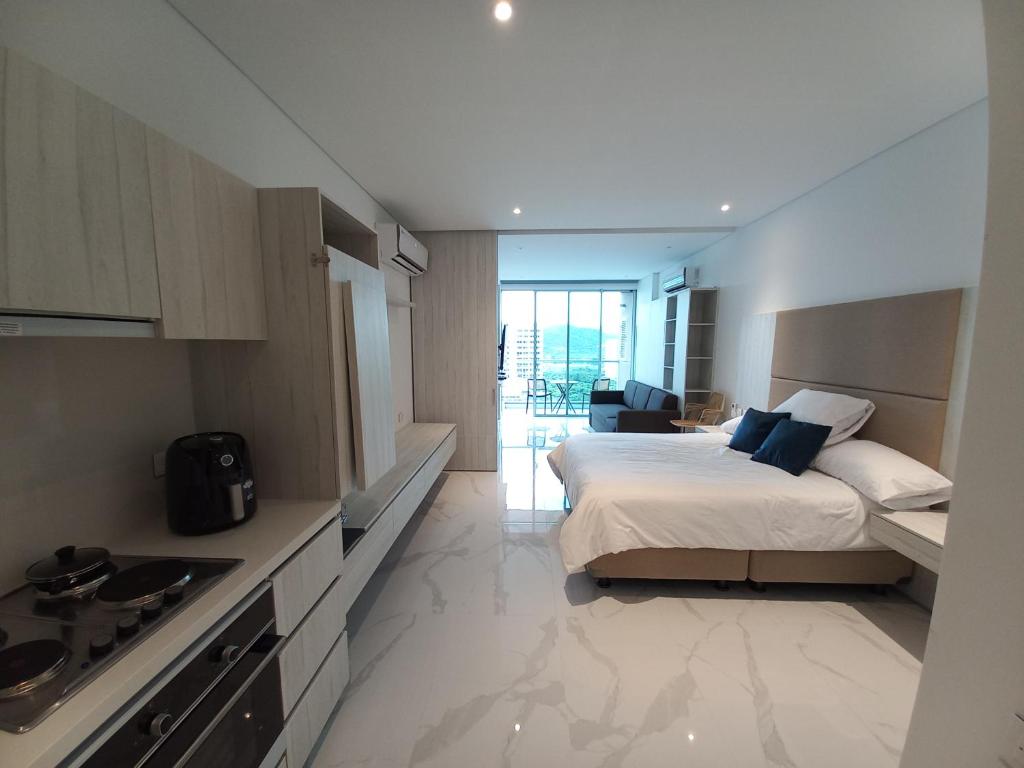 a bedroom with a bed and a kitchen with a sink at Playa y Relax comodidad junto al mar! in Santa Marta