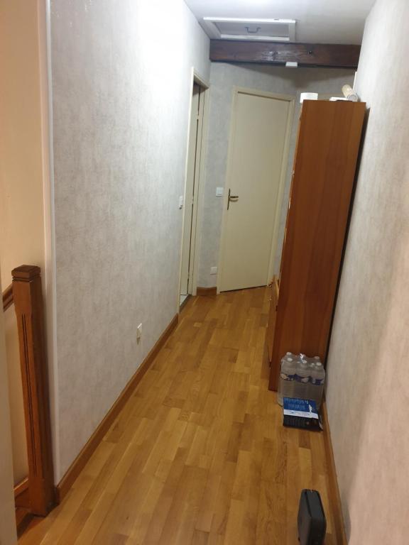 Una habitación vacía con un pasillo con piso de madera dura. en Noclegi77 - Auberge77, en Villiers-sous-Grez