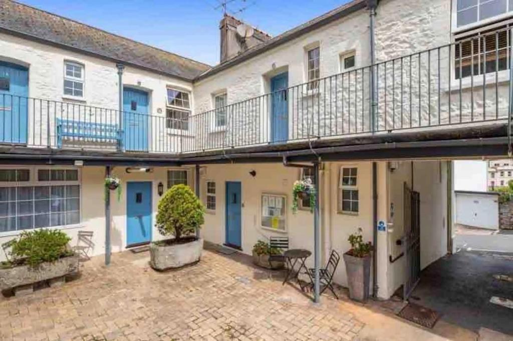 ein Mehrfamilienhaus mit blauen Türen und einem Balkon in der Unterkunft Centrally located, beautifully presented apartment in Torquay