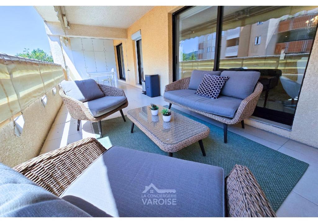 un balcon avec des chaises et une table sur un immeuble dans l'établissement Les Gregoriennes T2 Climatisé Hyeres Centre-Terrasse-Parking-Wifi, à Hyères