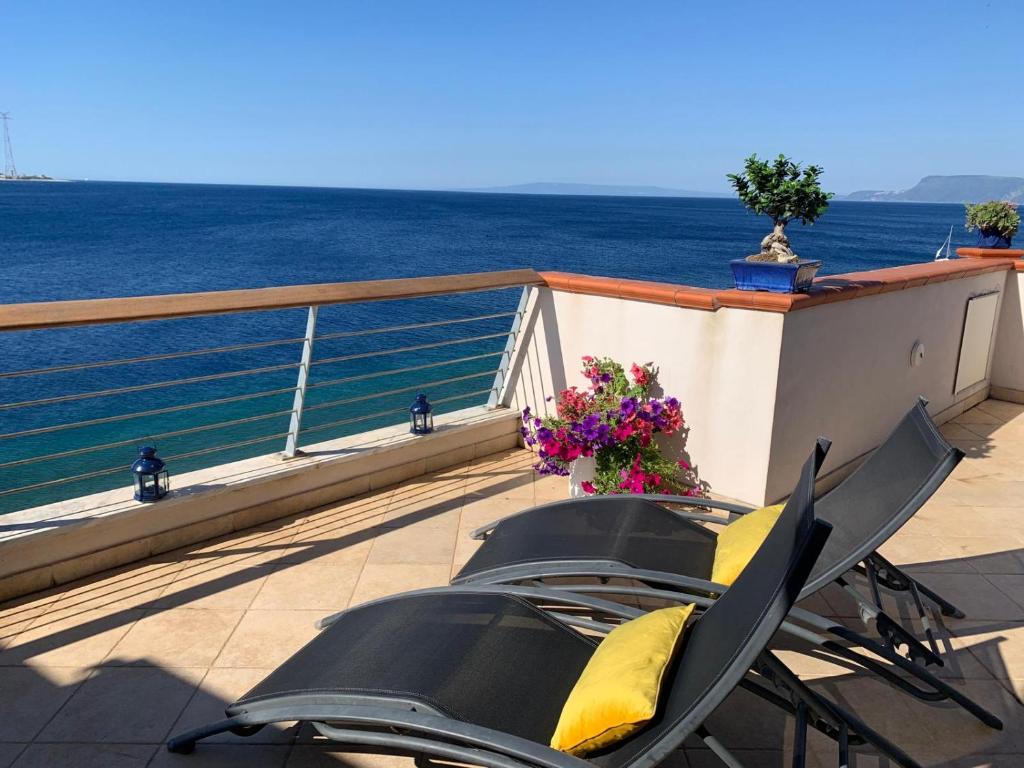 a table and chairs on a balcony overlooking the ocean at Blu Oltremare in Villa San Giovanni