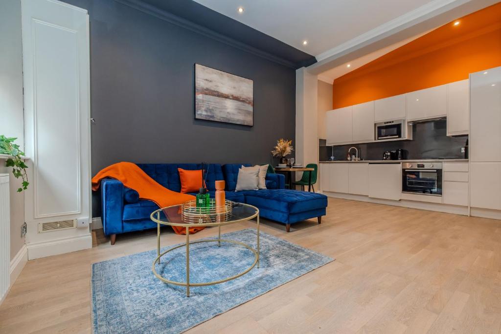 un salon avec un canapé bleu et une table dans l'établissement Super Central 1 Bedroom Flat With Balcony Next To Brighton Beach, à Brighton et Hove
