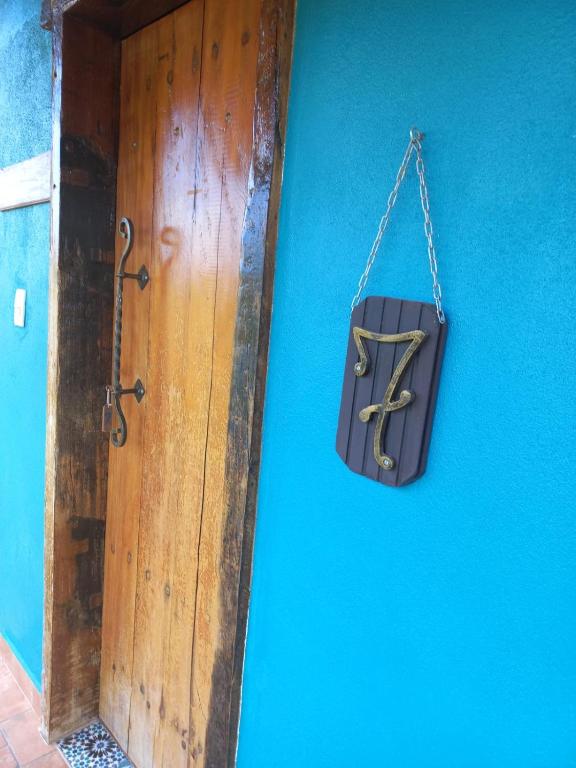 a bag hanging on a blue wall next to a door at Pousada Cachoeiras do Cipó in Serra do Cipo