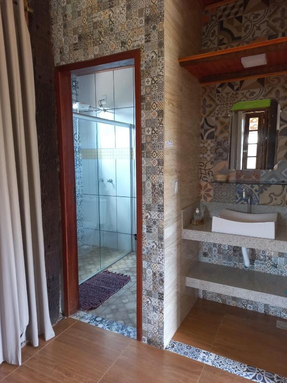 a bathroom with a mirror and a sink at Pousada Cachoeiras do Cipó in Serra do Cipo
