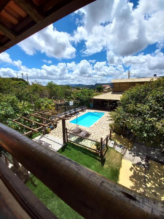 a view of a swimming pool from the balcony of a house at Pousada Cachoeiras do Cipó in Serra do Cipo