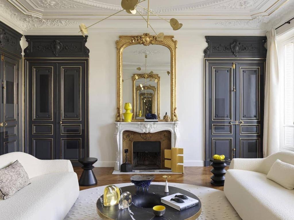 un salon avec une cheminée et un miroir dans l'établissement Champs-Élysées Arc de Triomphe, à Paris