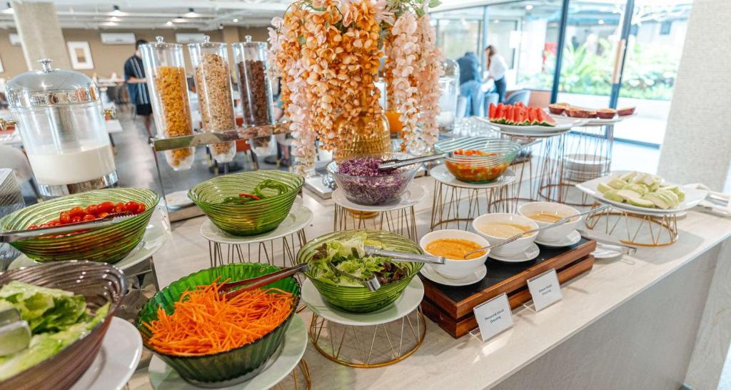 A bright buffet counter offers salads, vegetables, toppings, cereals, and sauces.