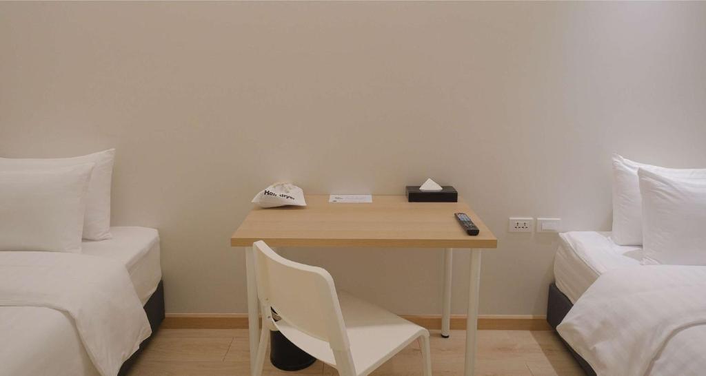 A narrow writing desk and chair fit between two single beds.
