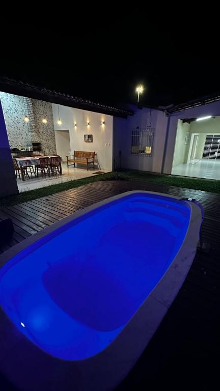 a blue swimming pool in front of a house at night at Casa Porto Mar in Aracaju