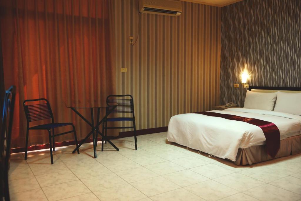 Postel nebo postele na pokoji v ubytování Jiuning Business Hotel