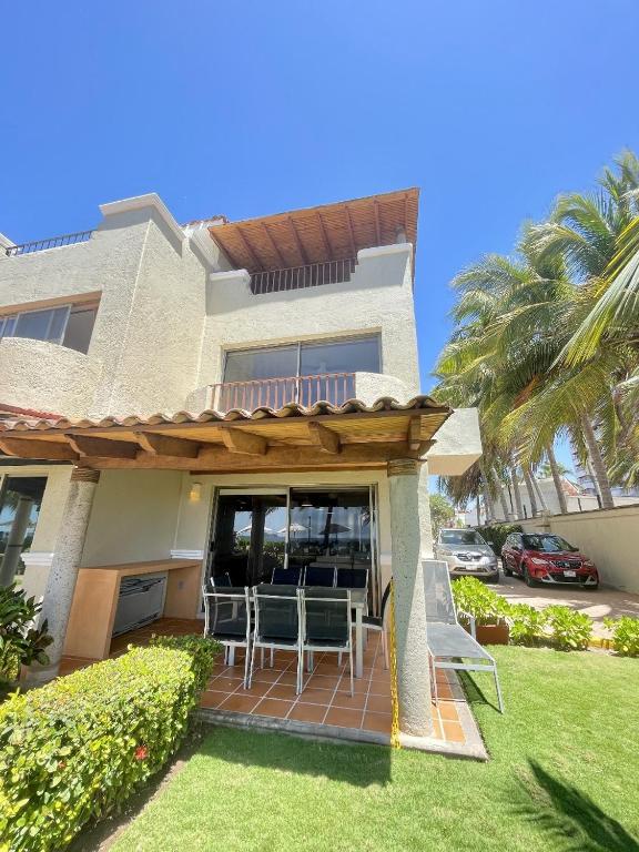 a house with a porch with chairs and a deck at Villa 8 frente al mar in Zihuatanejo