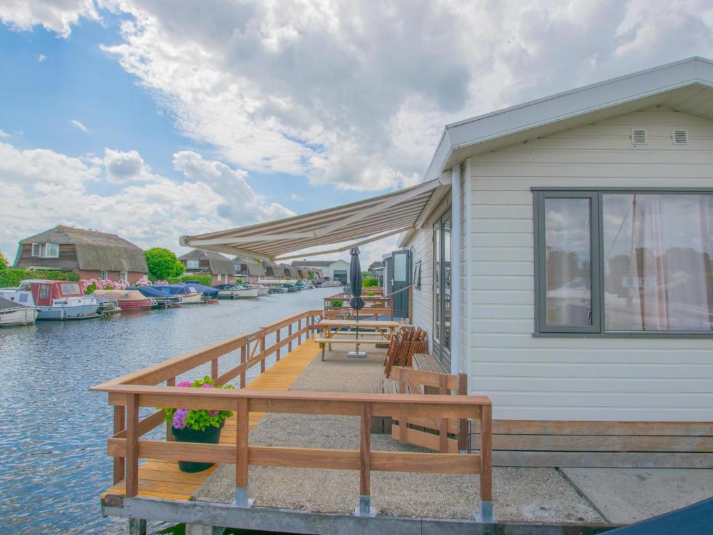 a house with a wooden dock with boats in the water at Blauwborst 24-24 in Breukelen